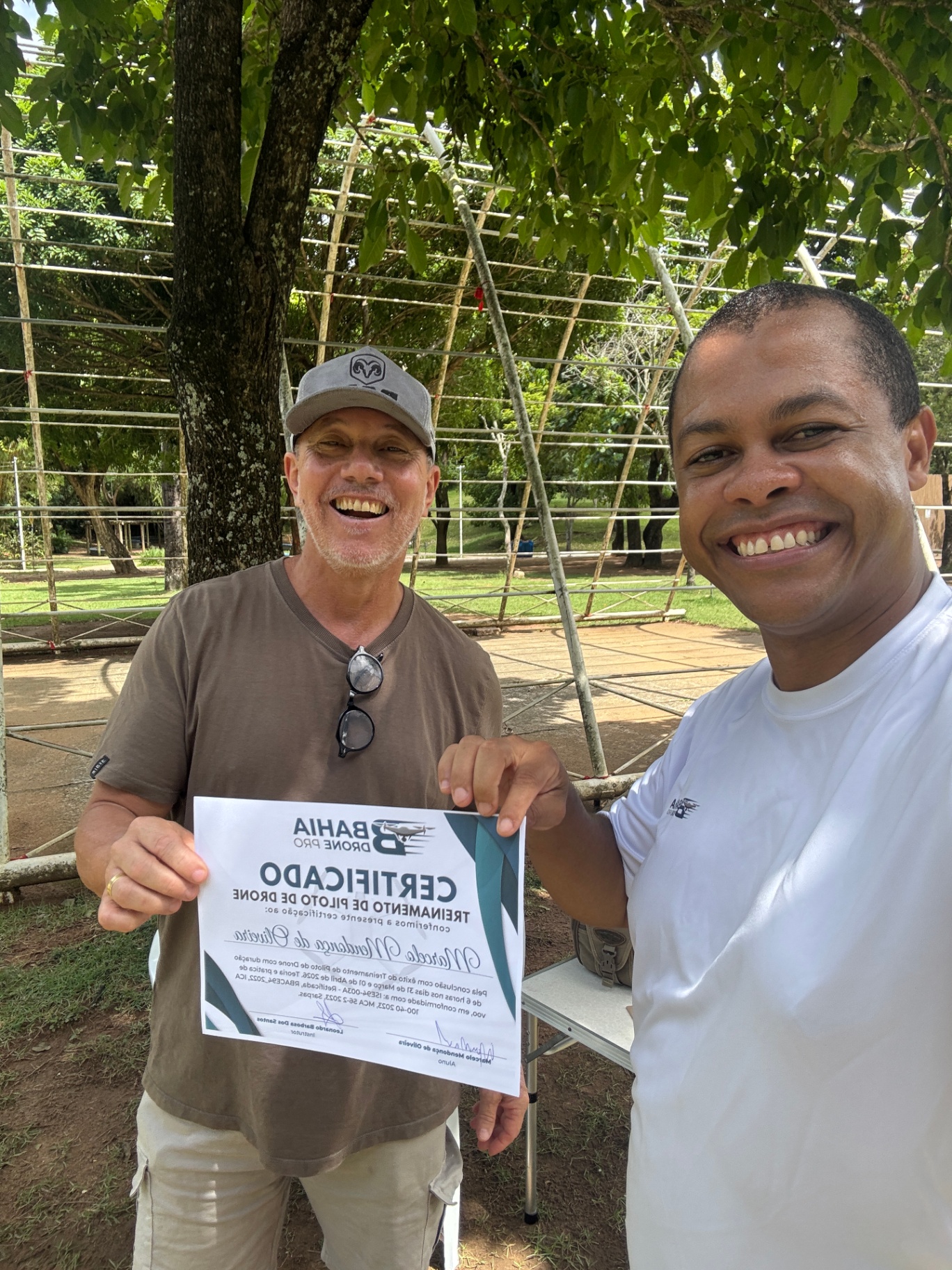 Aluno ao lado do instrutor exibindo certificado durante a imersão