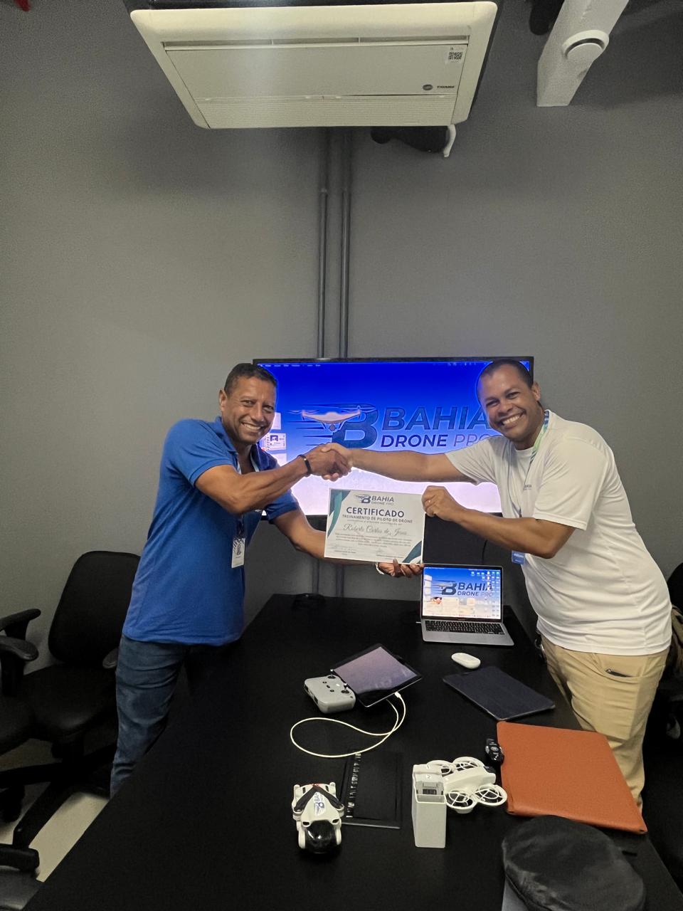 Instrutor entregando certificado ao aluno na sala de aula